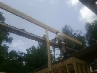 Carpenter setting a ridge beam over a new addition frame — Ice Dam Removal by Roofing Brothers in Blackwell