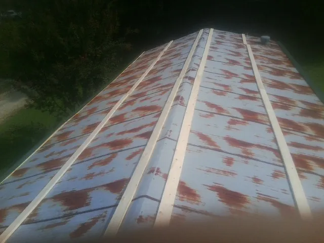 Rusted metal roof panels with new wood purlins before replacement — Storm Damage Roof Repair in Blackwell by Roofing Brothers