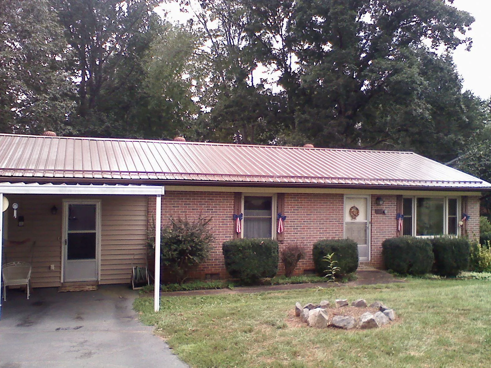 Bronze metal roof and carport on a brick ranch home — Roof Repair work by our crew in Blackwell